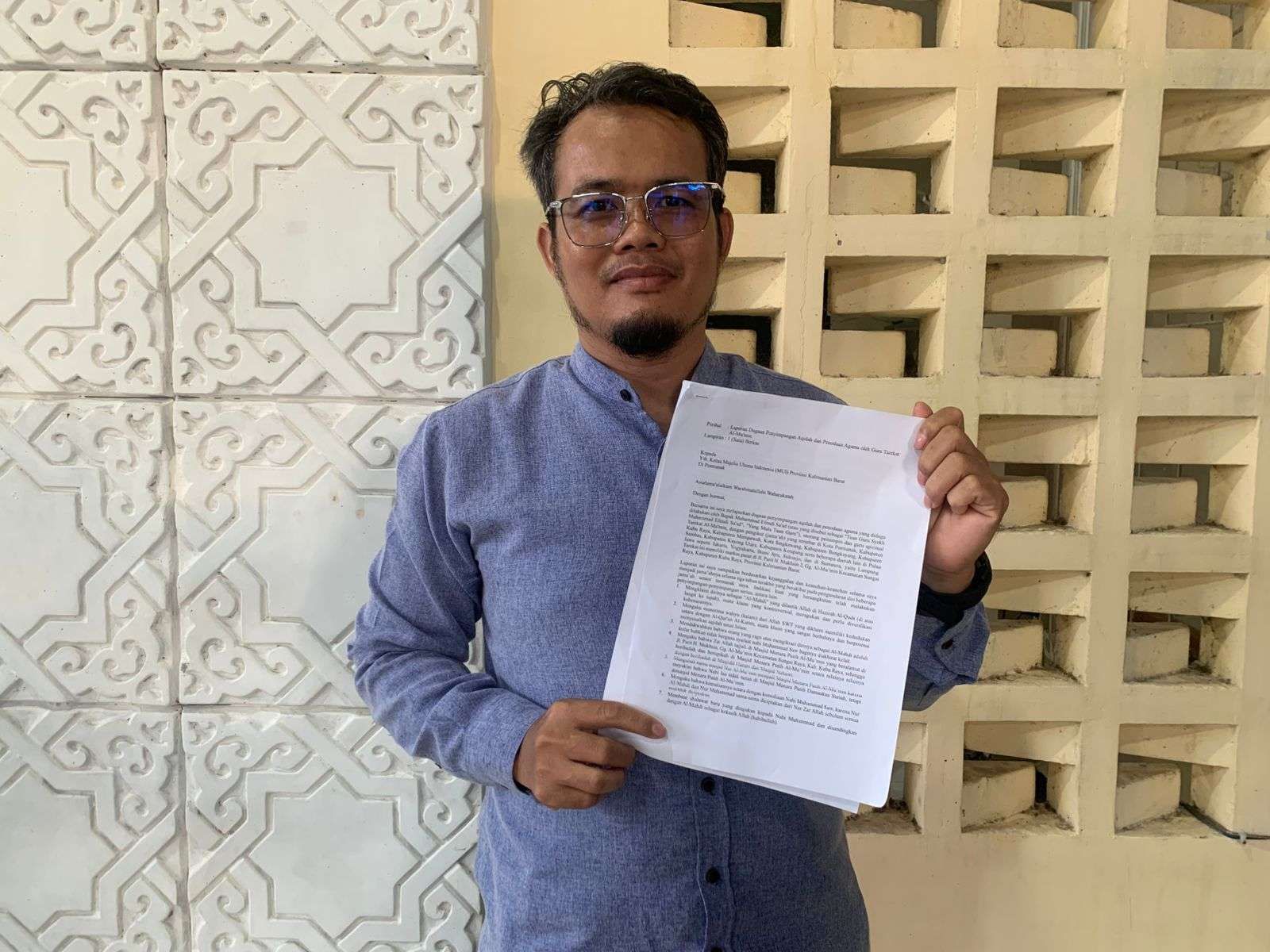 Pelapor Sumin menunjukkan berkas laporan pimpinan Masjid Al-Mu'min Sungai Raya ke MUI Kalbar, Rabu (16/4/2025)